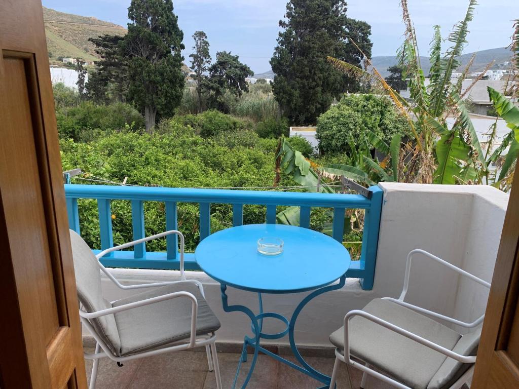 uma mesa azul e cadeiras numa varanda com vista em Anixi em Astypalaia