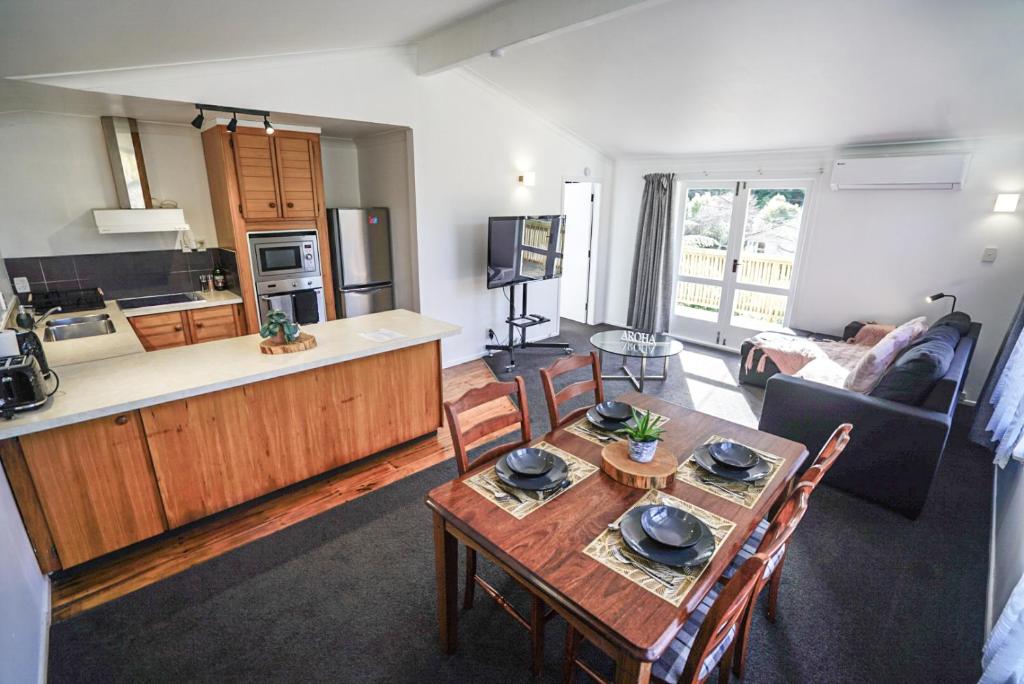 a kitchen and a living room with a table and chairs at The Hidden Gem - tranquility close to town in Wellington