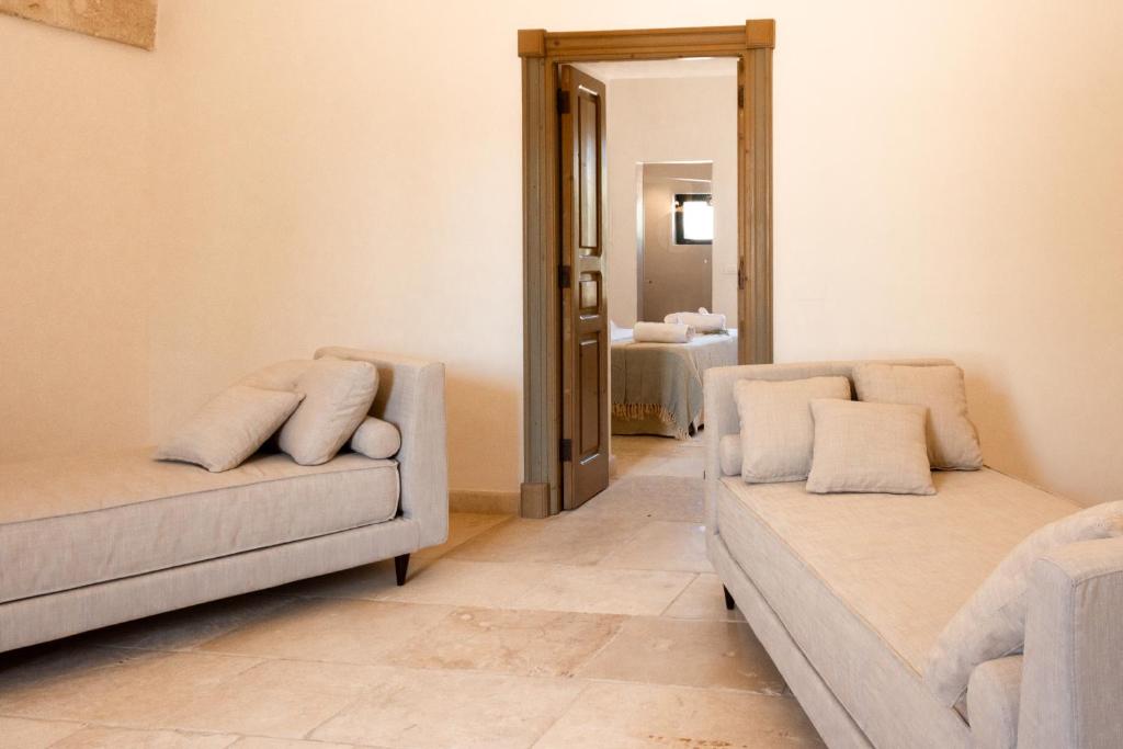 a living room with two couches and a mirror at Masseria Gorgognolo in Ostuni