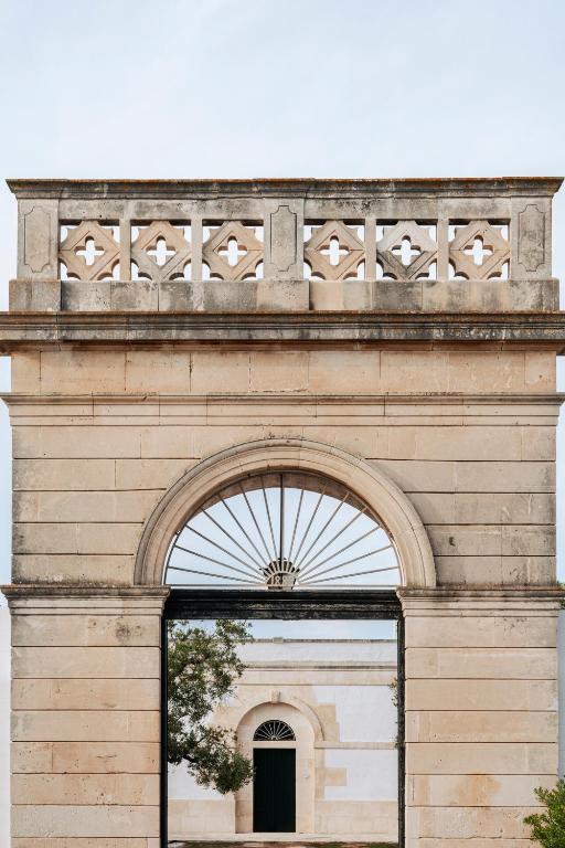 a building with an arch with a window at Masseria Gorgognolo in Ostuni