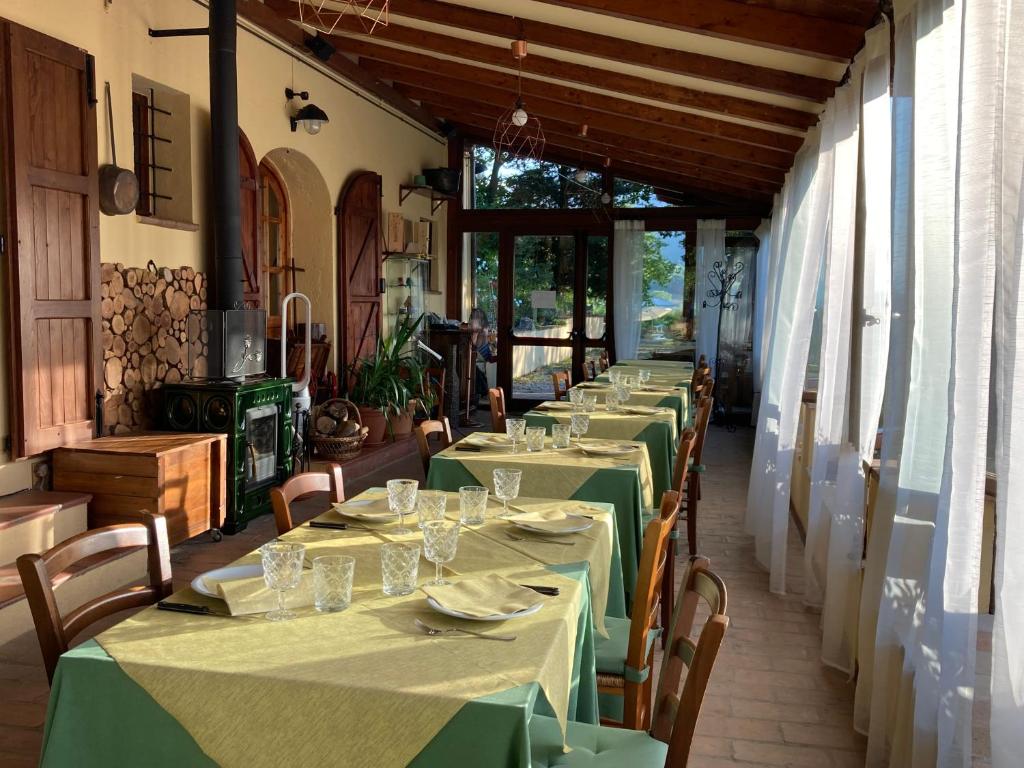 een rij tafels in een restaurant met groen tafellinnen bij Agriturismo Gioie di Campagna in Fabriano
