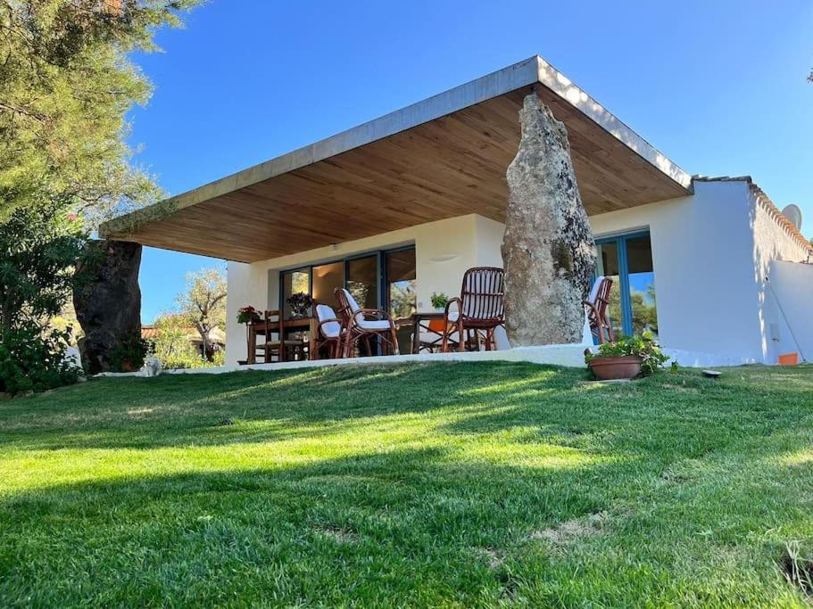 a small white house with a large grass yard at Newly renovated traditional Sardinian dwelling in Porto Rotondo