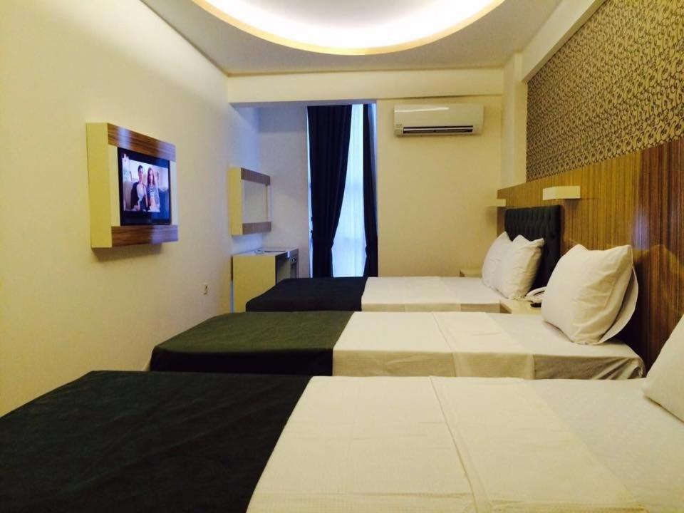 メルスィンにあるGrand Mardin Hotelのベッド2台とテレビが備わるホテルルームです。