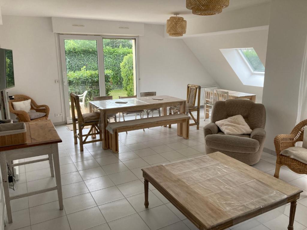 sala de estar con mesa y sillas en Maison familiale dans une rue paisible, en Gouville-sur-Mer