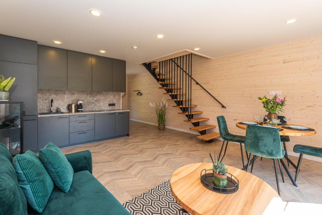 un soggiorno con un divano verde e un tavolo di Sodyba pas Brolius - Mažasis Namelis - Entire Barn House 85m2 a Priekulė