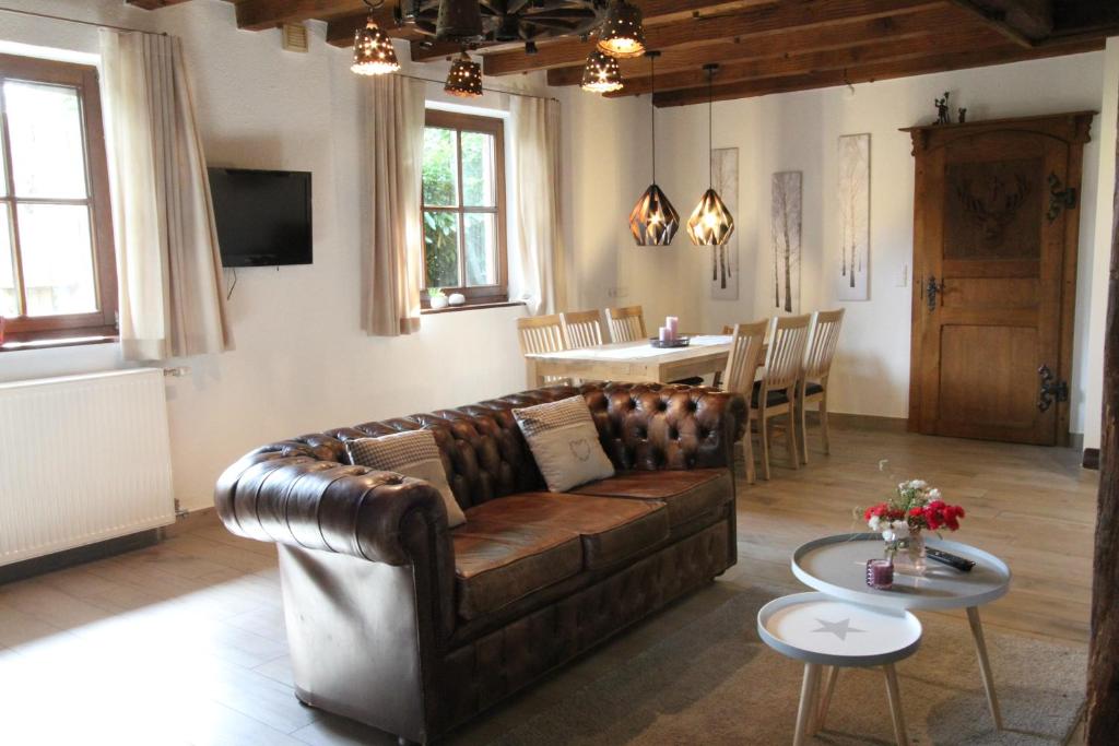 uma sala de estar com um sofá de couro e uma mesa em Ferienhaus Schulze Beikel em Borken