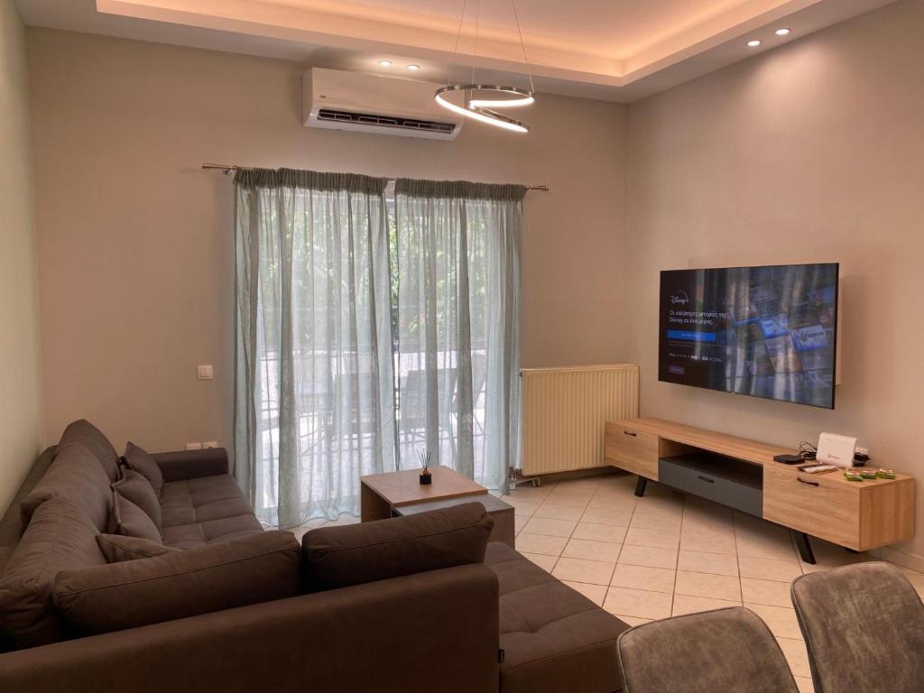 ein Wohnzimmer mit einem Sofa und einem Flachbild-TV in der Unterkunft Comfortable Apartment Near to Metro & Hospitals in Athen