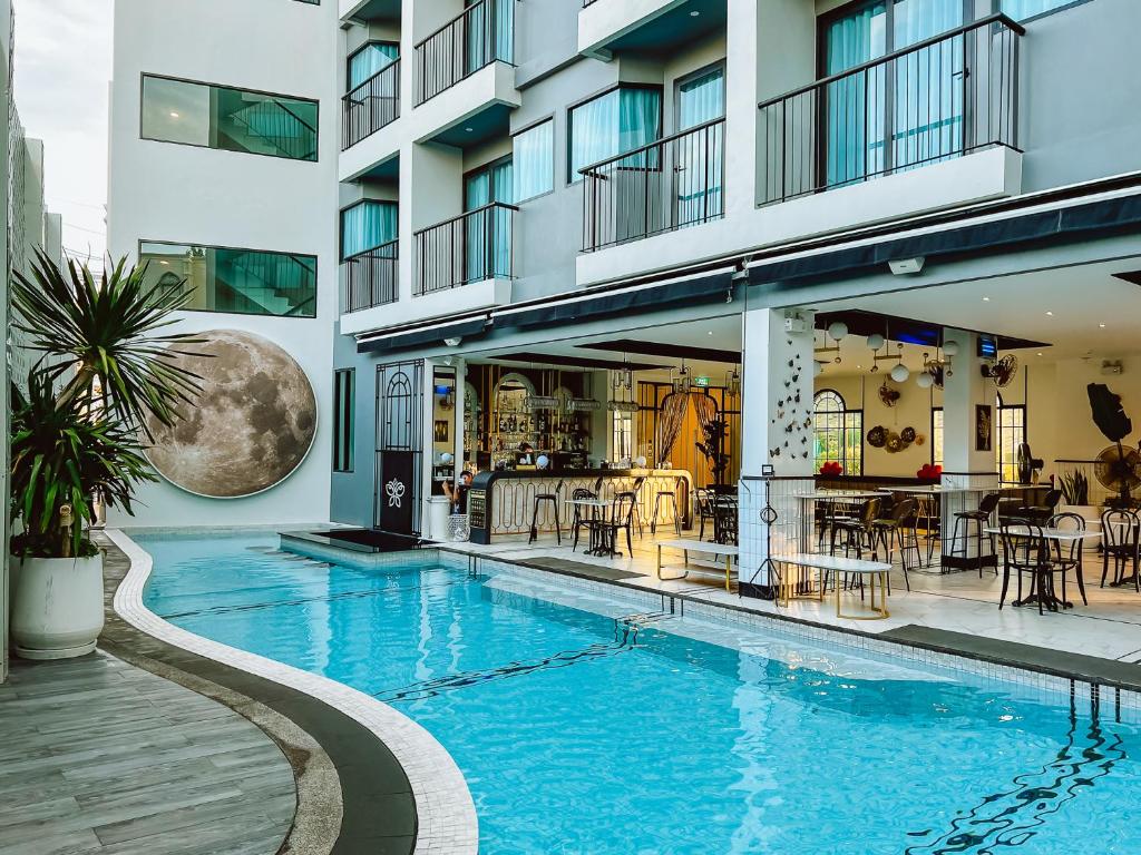 a swimming pool in a building with a restaurant at Ratri Hotel Phuket Old Town in Phuket Town