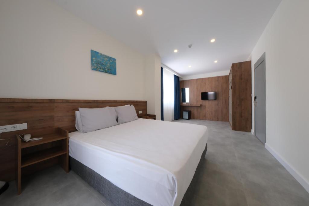 ein Schlafzimmer mit einem großen weißen Bett in einem Zimmer in der Unterkunft Premier İnn Cİty in Antalya