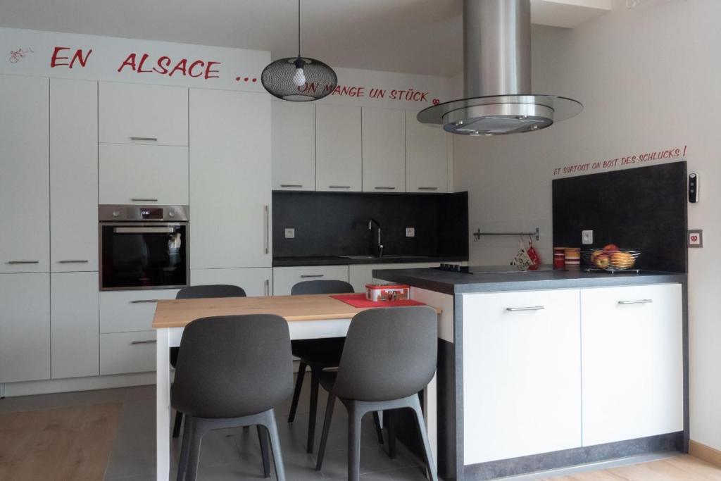 a kitchen with a table and chairs in a room at A l Orée du Bois in Rimbach-près-Masevaux