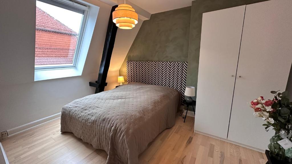 a bedroom with a bed and a window at Carolinas Apartment - Løvstræde in Copenhagen