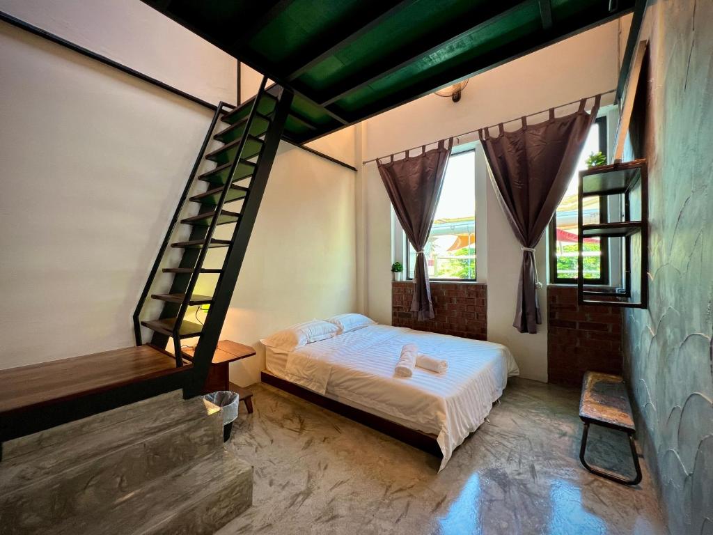 1 dormitorio con 1 cama y escalera de caracol en DoSomething Guest House 2 en Ipoh