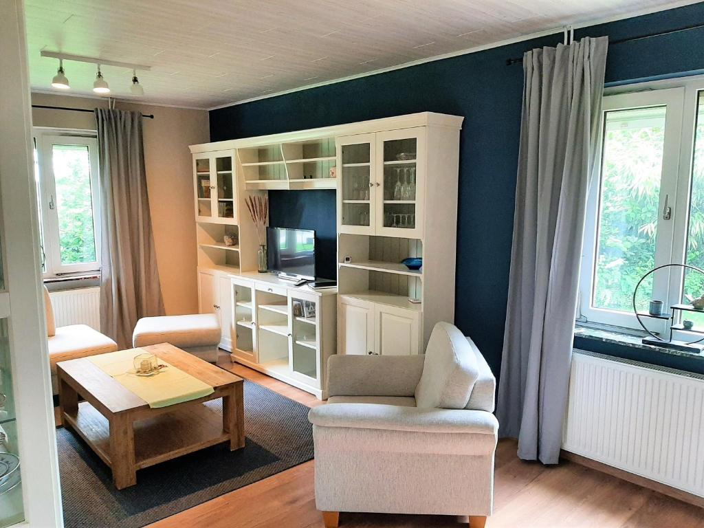 a living room with a white cabinet and a table at Huus de Freese 35224 in Beningafehn