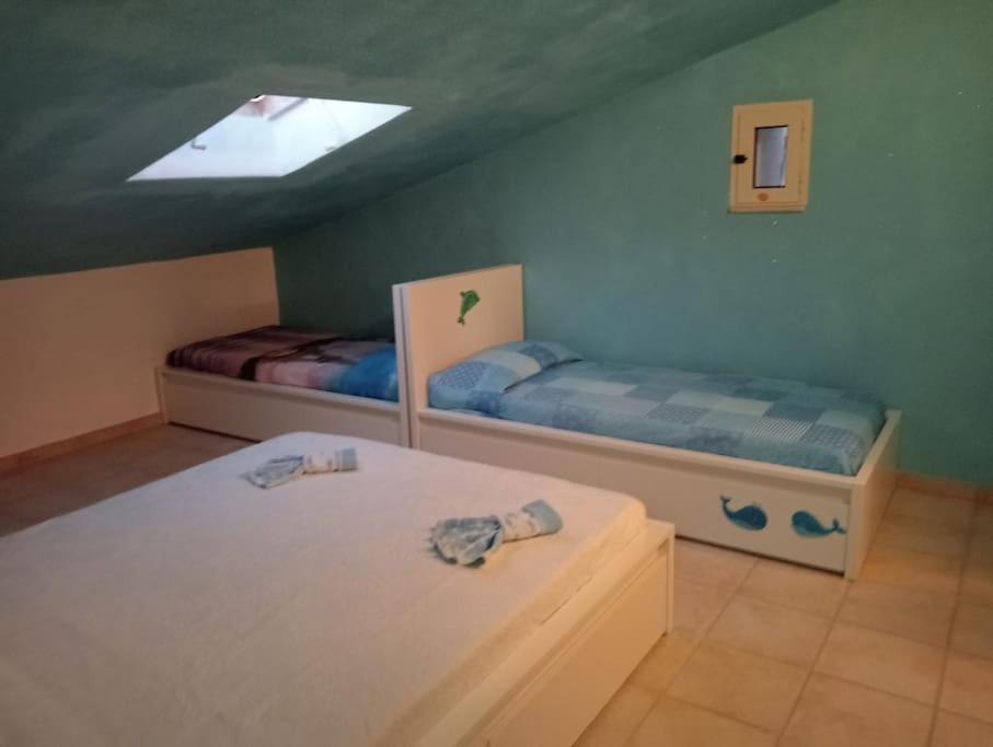 1 dormitorio con 2 camas y tragaluz en casetta al mare, en Sapri