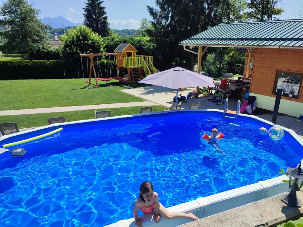 拉多夫利察的住宿－Apartments and Wellness Jelovca，两个孩子在蓝色的大游泳池玩耍