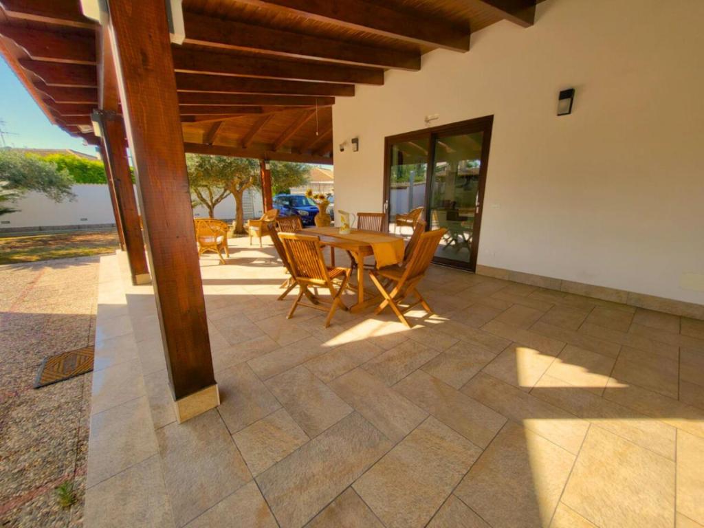 an outdoor patio with a wooden table and chairs at Scirocco Home in Marsala