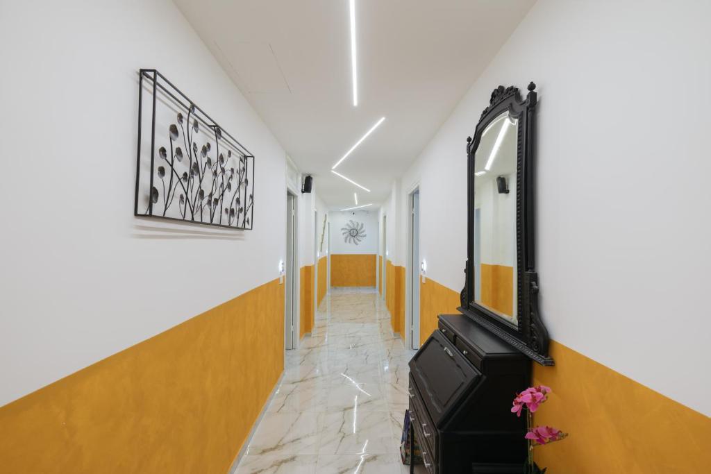 a hallway with orange and white walls and a mirror at AFFITTACAMERE ELENA in Sanremo