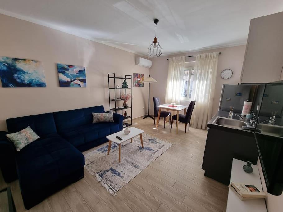 een woonkamer met een blauwe bank en een tafel bij Brian's Apartment in Tirana in Tirana