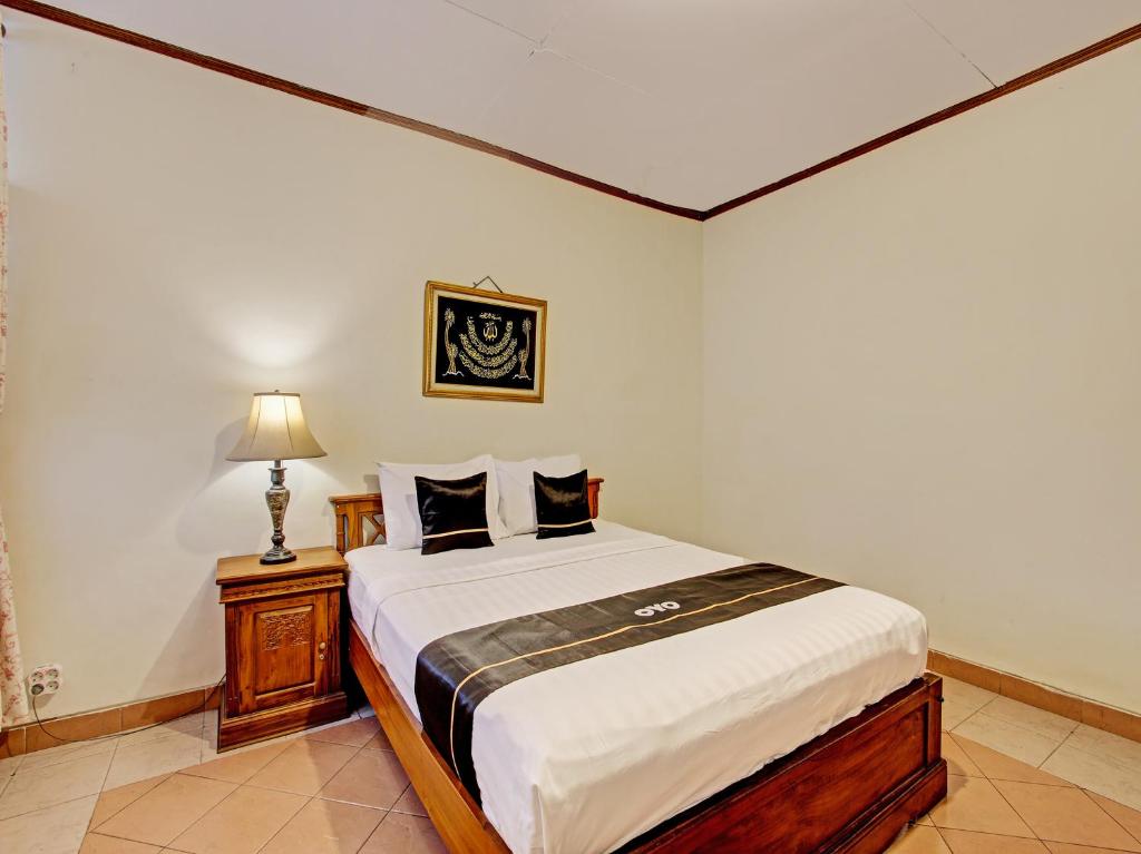 a bedroom with a bed and a lamp in it at Capital O 92894 Griya Lathifah Homestay Syariah in Kalasan