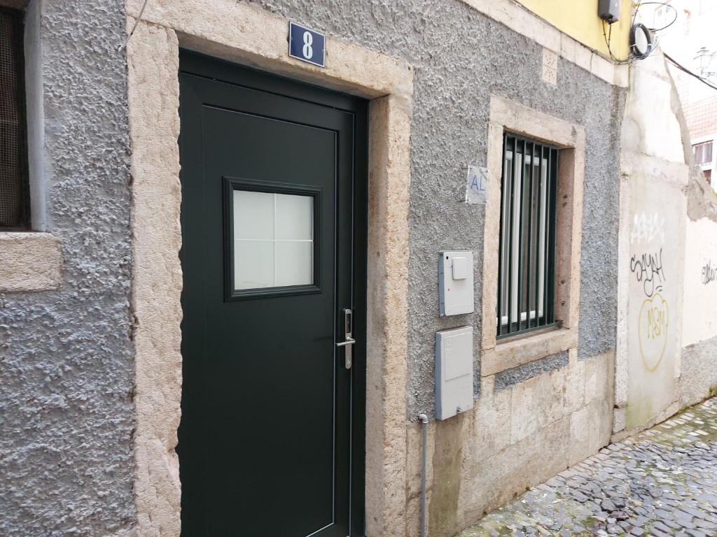 eine schwarze Tür an der Seite eines Gebäudes in der Unterkunft STUDIO MADALENA in Lissabon