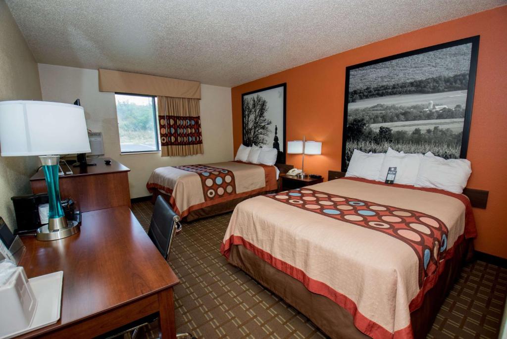 a hotel room with two beds and a desk at Super 8 by Wyndham Altoona in Altoona