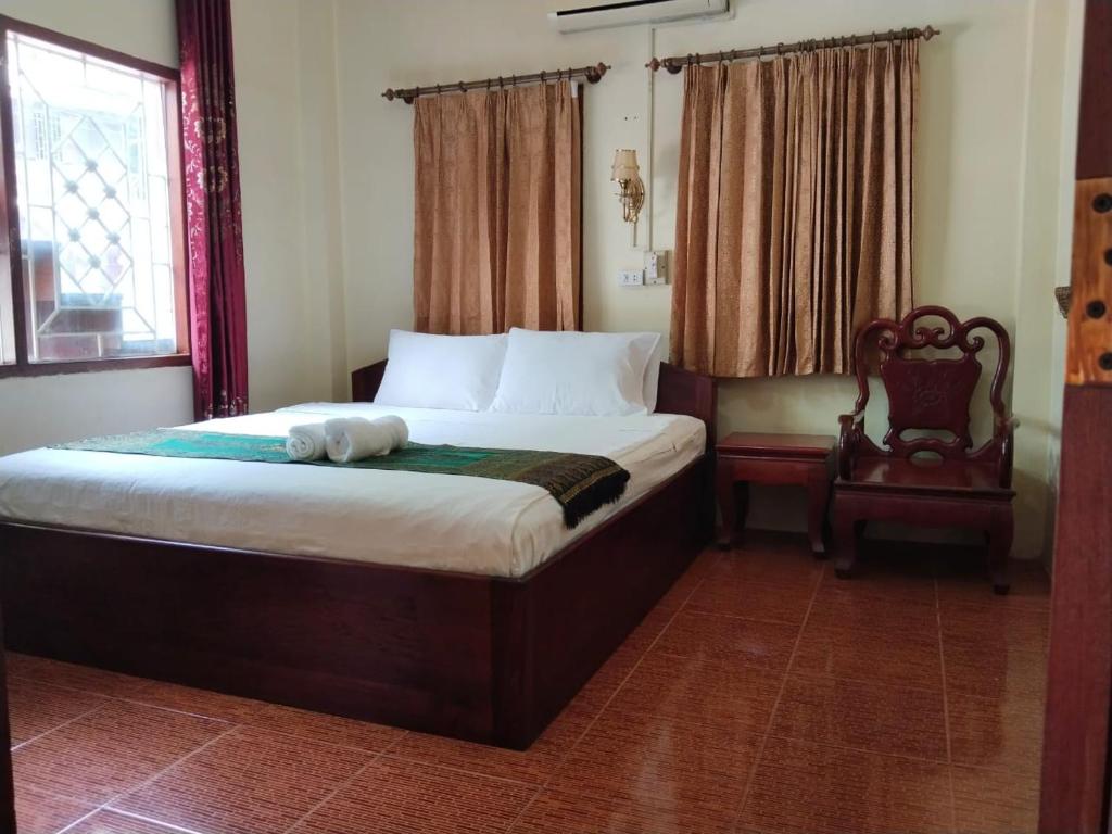 Thipphaphone Guesthouse في باكبنج: غرفة نوم مع سرير مع دمية دب عليها
