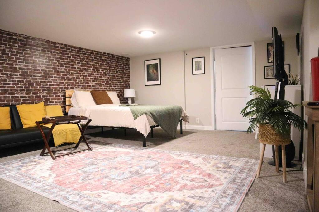 um quarto com uma cama e uma parede de tijolos em Modern Industrial 1BR W/ Gym, Work Desk and More! em Dent