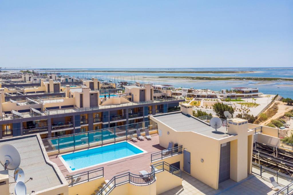 een luchtzicht op het resort met de oceaan op de achtergrond bij Apartamento Stella Maris in Olhão