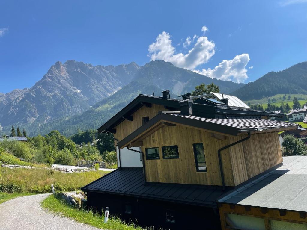 uma casa ao lado de uma estrada com montanhas em Alpenglück - Hinterthal em Hinterthal