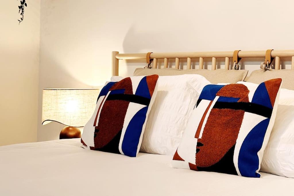 ein Bett mit zwei Kissen darüber in der Unterkunft Colorful Coziness City Apartment in Gent