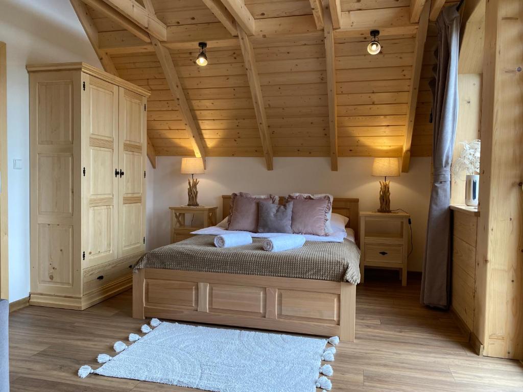 1 dormitorio con cama y techo de madera en Osada Snozka, en Kluszkowce