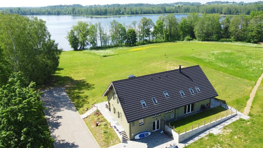 - une vue sur une maison dotée d'un grand champ dans l'établissement Palaima Hotel Anykščiai, à Anykščiai