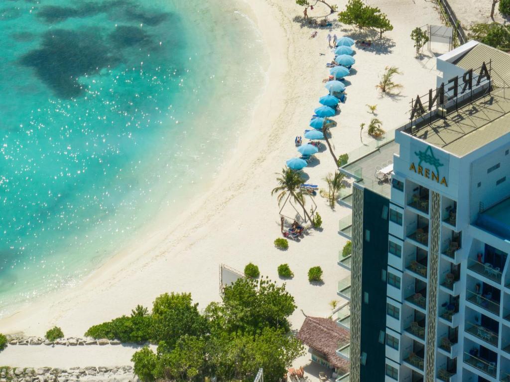 uma vista para a praia a partir da varanda de um resort em Arena Beach Hotel em Maafushi