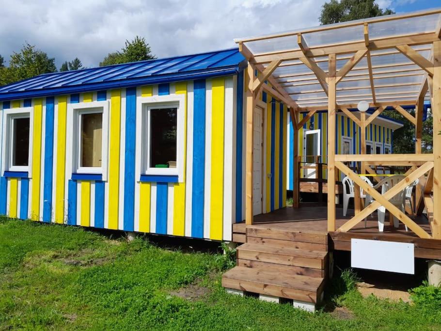 una casa pequeña y colorida con terraza en Camping Fluffy Horns - Kempings Pūkainie Ragi, en Plieņciems