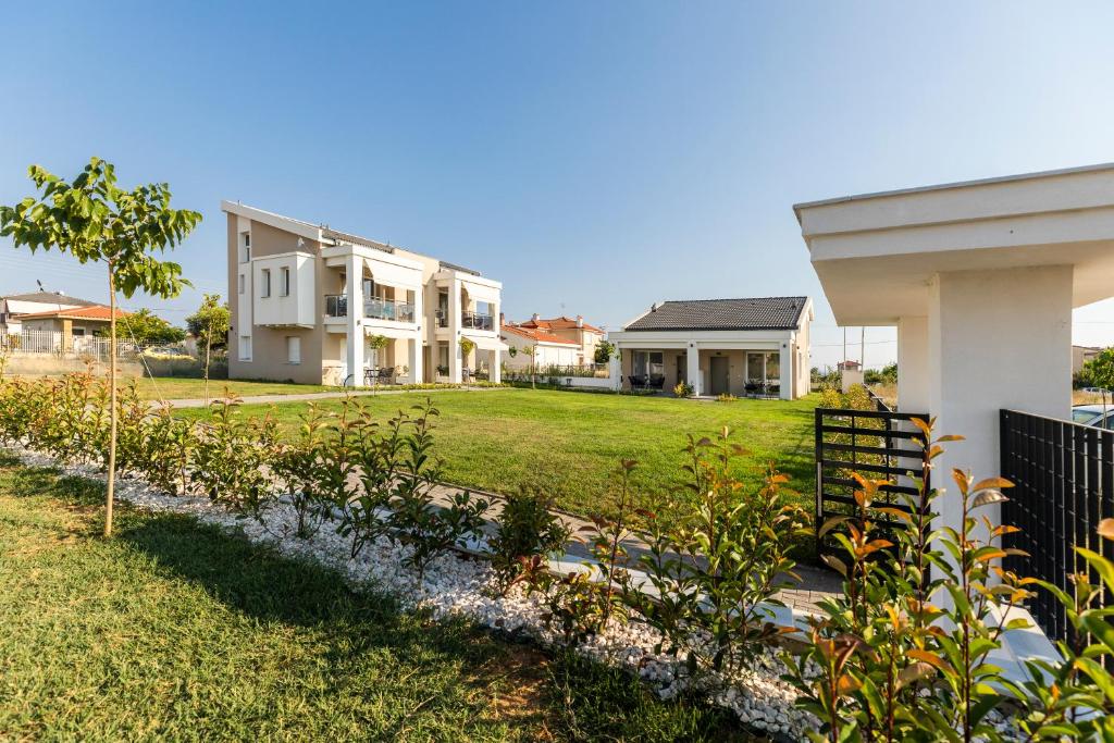une maison dotée d'une cour avec des plantes devant elle dans l'établissement Bianco Mare Studios-Apartments, à Kalivia Poligirou