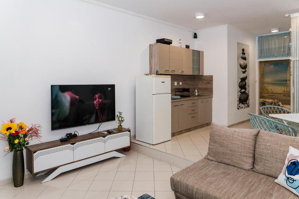 a living room with a couch and a tv on a wall at Луксозен апартамент Далия in Varna City