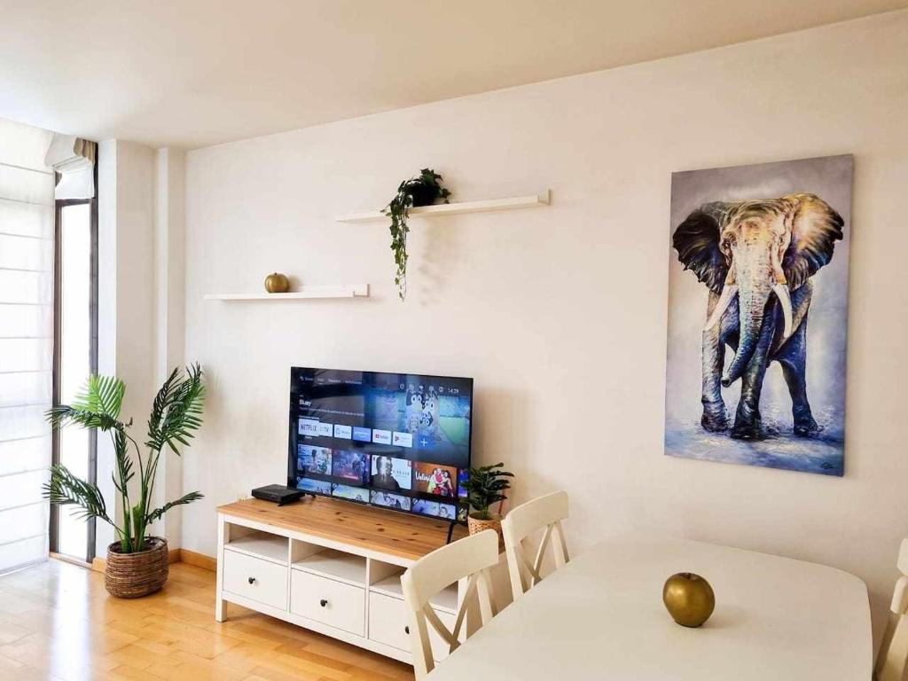 a living room with a television and a table with a tableablish at El Elefante del Pilar ComoTuCasa in Zaragoza
