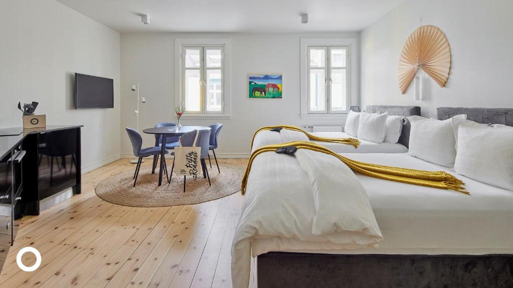 a white bedroom with a large bed and a table at Thingholt Hotel Apartments from Center Hotels in Reykjavík