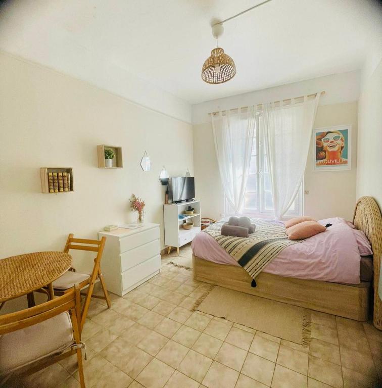 une chambre avec un lit, une table et une fenêtre dans l'établissement Cocooning Trouville, à Trouville-sur-Mer