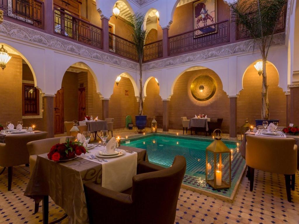 un restaurant avec une piscine au milieu d'un bâtiment dans l'établissement Riad Magda & Spa, à Marrakech