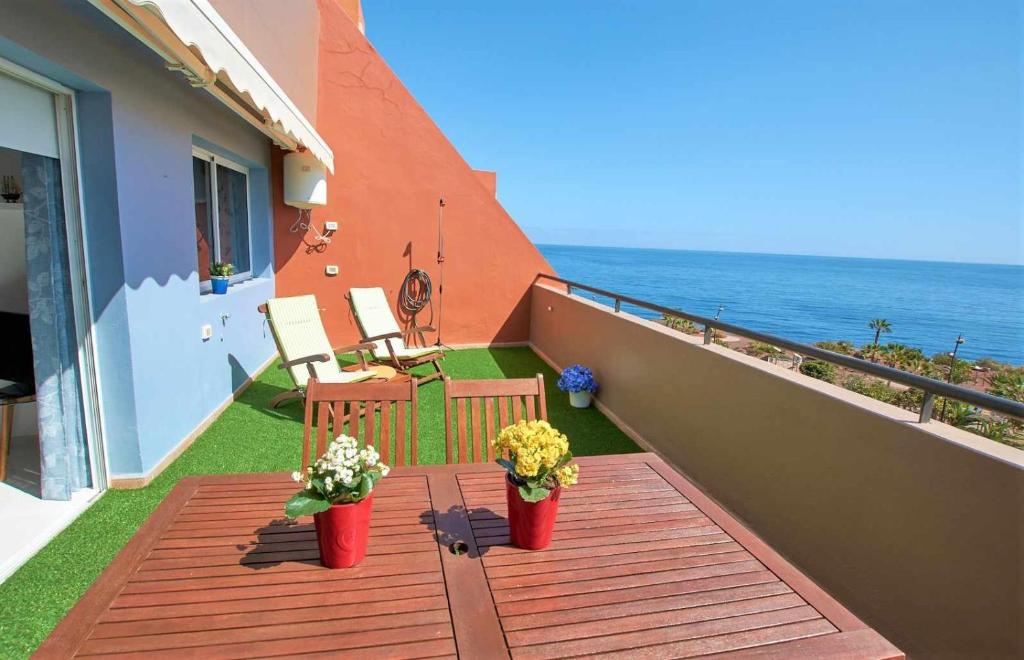 einen Balkon mit zwei Topfpflanzen und dem Meer in der Unterkunft Bonita vivienda con vistas al mar playaWIFI in Radazul