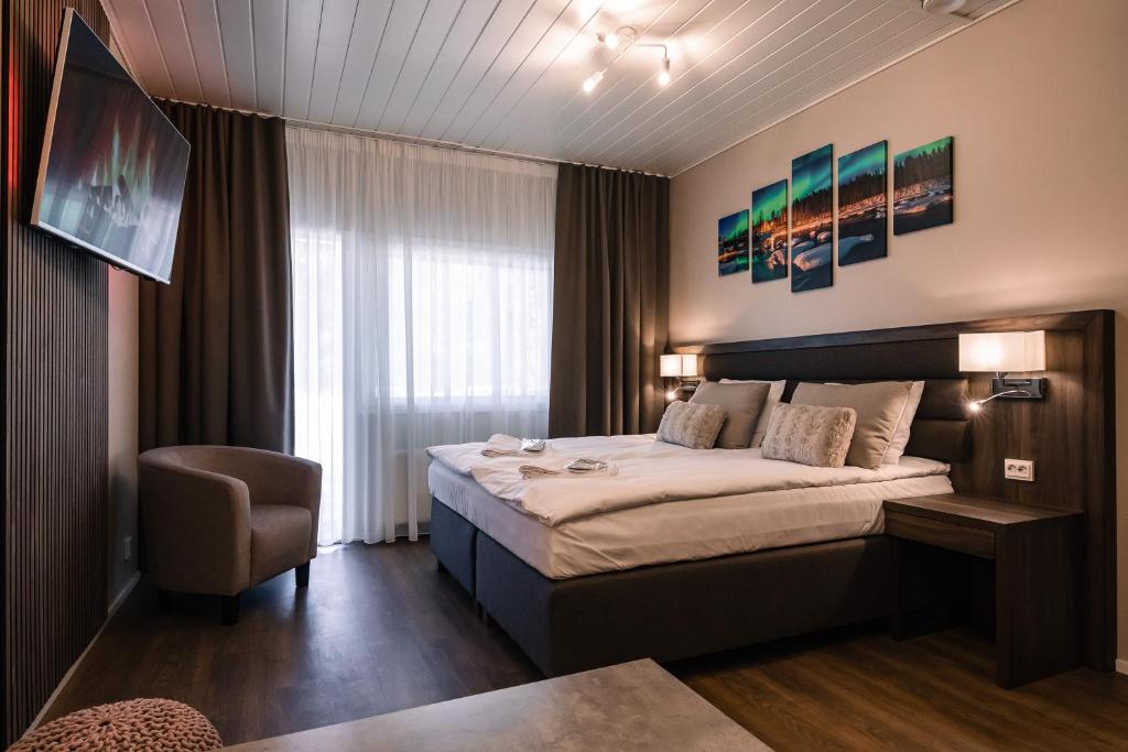 a hotel room with a bed and a chair at Hotel Boreas in Rovaniemi