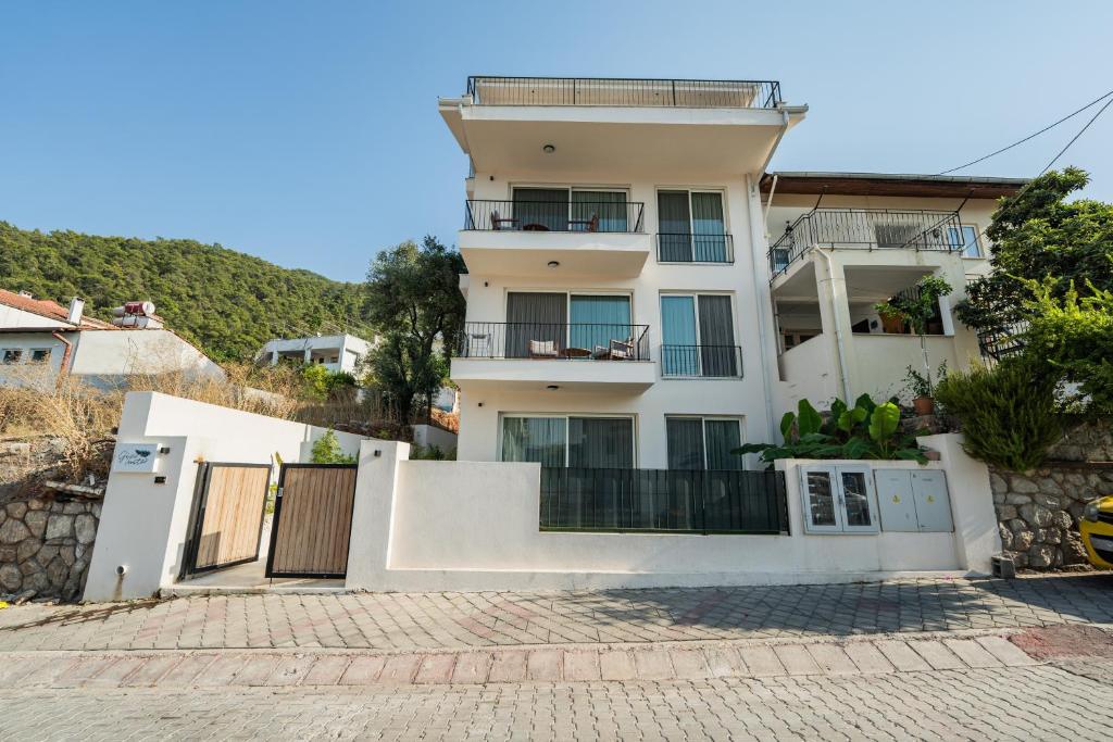 een groot wit huis met een balkon bij Gizz Suites City in Fethiye