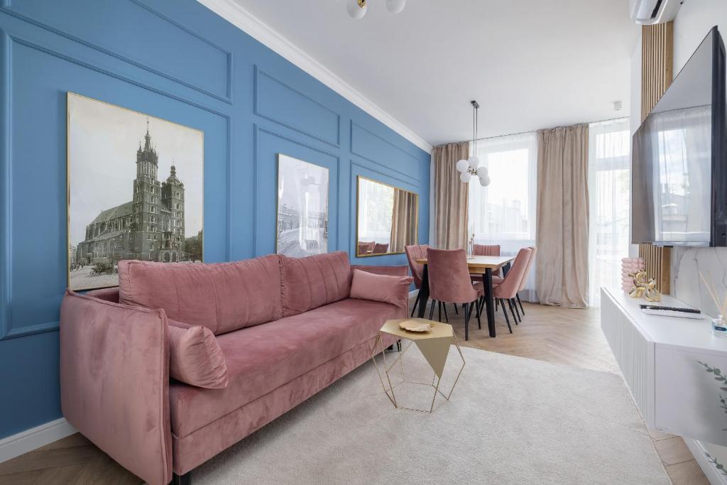 a living room with a pink couch and a table at Starowiślna Elegant Apartment with Air Conditioning Kazimierz Cracow by Renters Prestige in Krakow