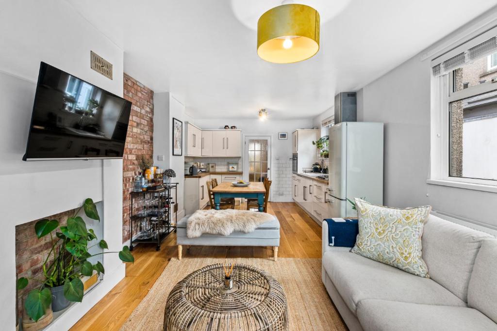 a living room with a couch and a kitchen at Lovely 2 bed Streatham apt with outside dining in London