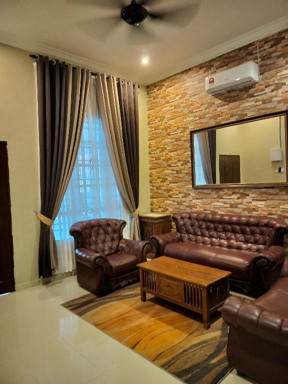 a living room with leather furniture and a mirror at ZR Homestay in Jitra