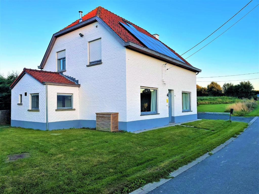 a white house with a red roof on a yard at Vakantiewoning in het landelijke Staden! 10 pers - STAEDENBERGH in Staden