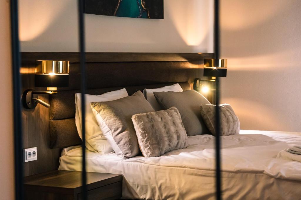 ein Schlafzimmer mit einem Bett mit weißen Laken und Kissen in der Unterkunft Hotel Boreas in Rovaniemi