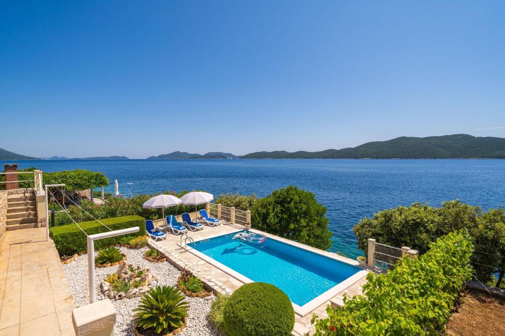 a swimming pool with a view of the water at House Planika in Slano