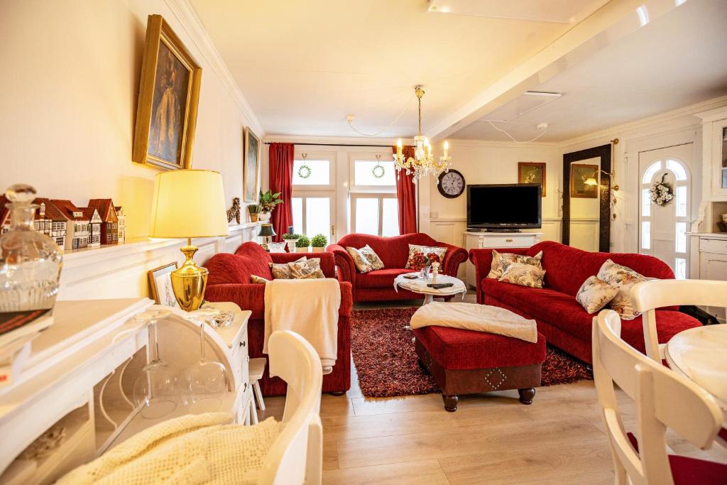 uma sala de estar com sofás vermelhos e uma televisão em Die Kleine Oase em Stuhr